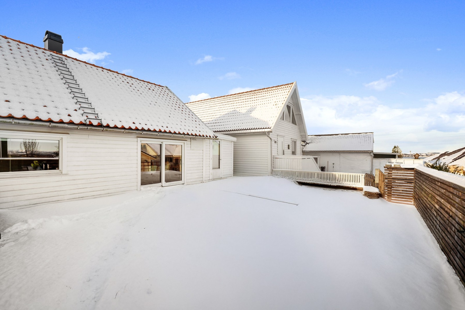 Terrassen måler ca. 48 kvm, og rammes fint inn av en hekk langs rekkverket Galleribilde