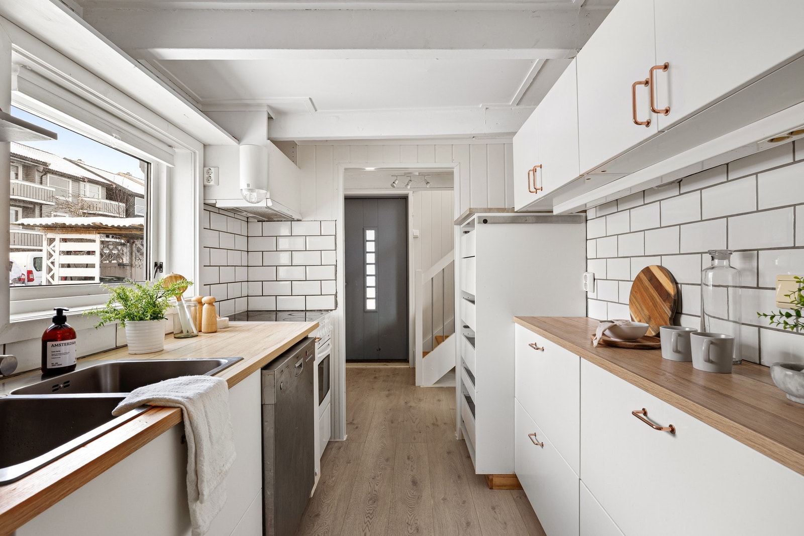 Entreen glir sømløst over i kjøkkenet, med den samme 1-stavs parketten Galleribilde