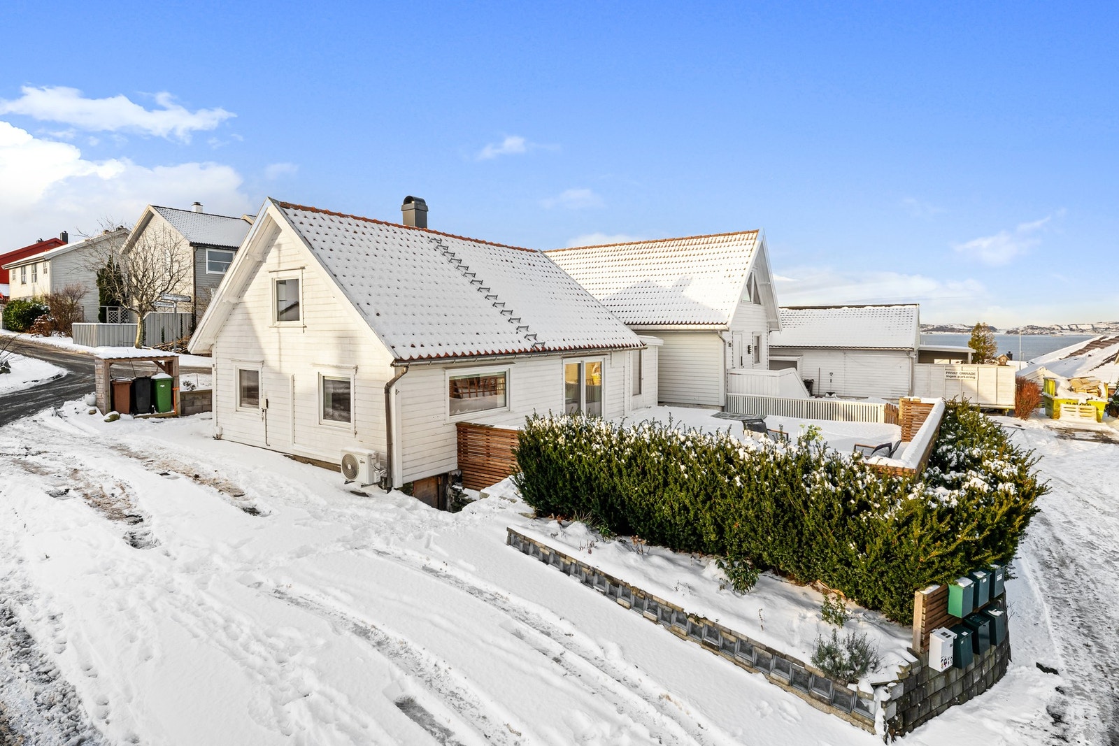 Tomten har parkering ved siden av huset, der en lader for elbil ble installert i 2025 Galleribilde