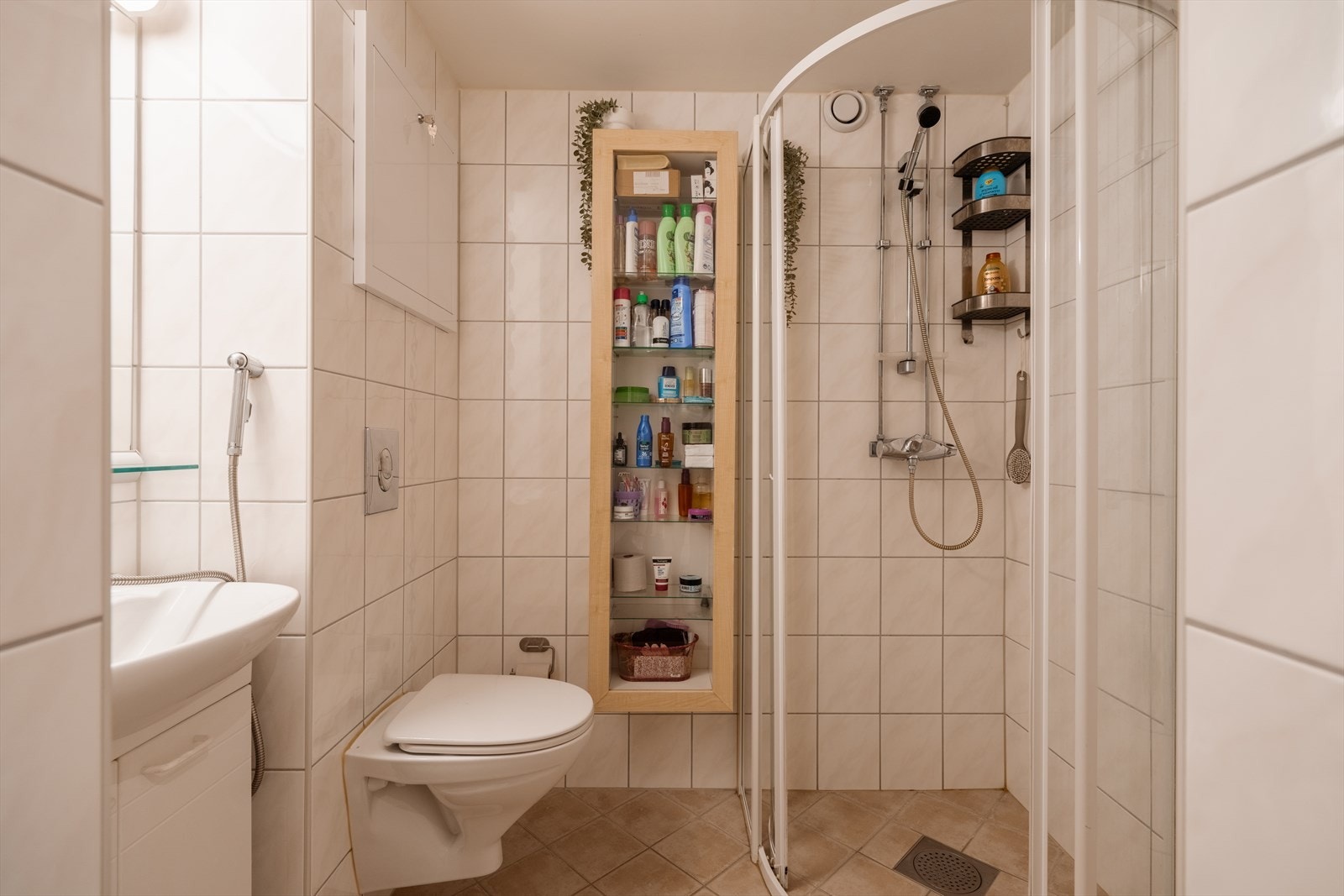 Delikat flislagt baderom med vegghengt toalett. Galleribilde