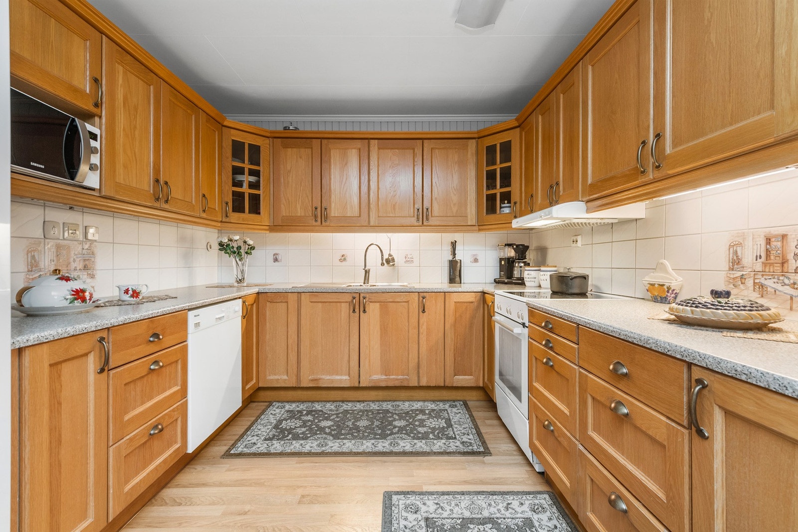 Kjøkken med innredning fra 2002. Innredningen har profilerte fronter og en laminat benkeplate. Galleribilde