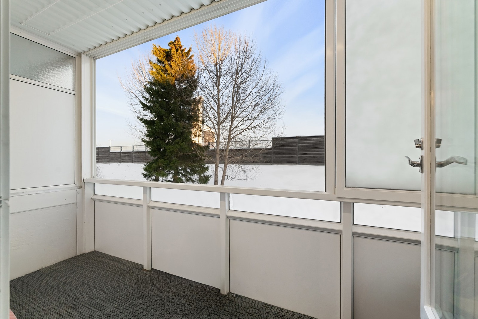 Fra den andre siden av stuen er det utgang til en innglasset balkong med utsikt mot hagen. Galleribilde