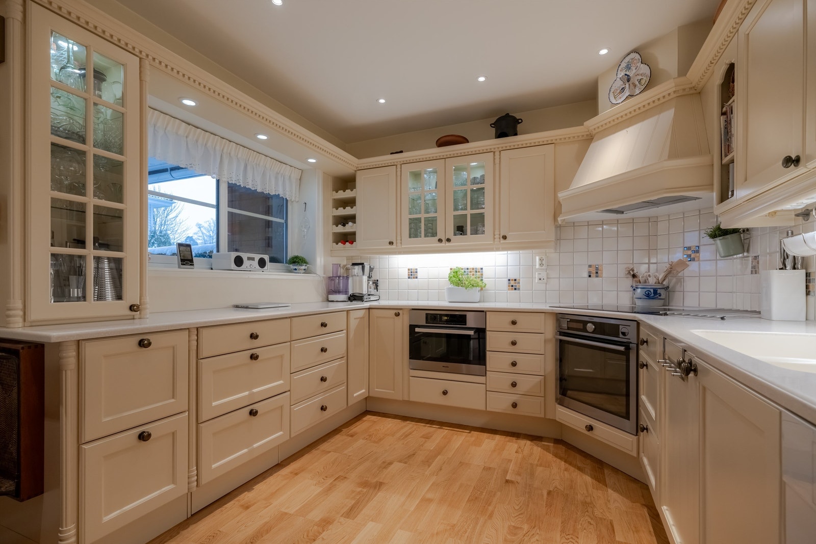 Hyggelig kjøkken med innredning fra Huseby. Benkeplaten er i kompositt med nedsenket oppvaskkum. Galleribilde