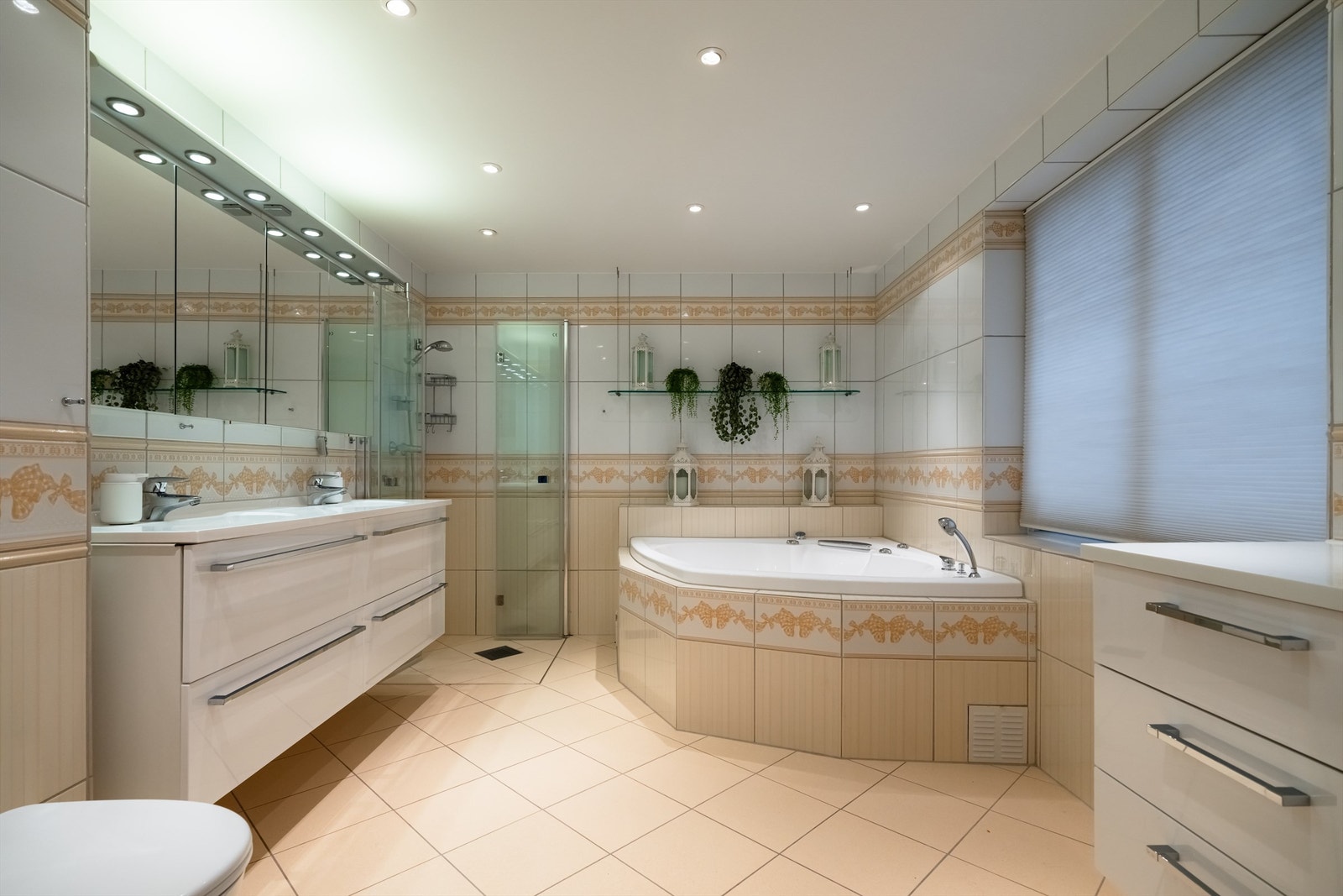 Romlig, flislagt bad med gulvvarme. Innredet med vegghengt servantskap med ovenpåliggende dobbeltvask, egen dusjnisje og innmurt boblebadekar.
. Galleribilde