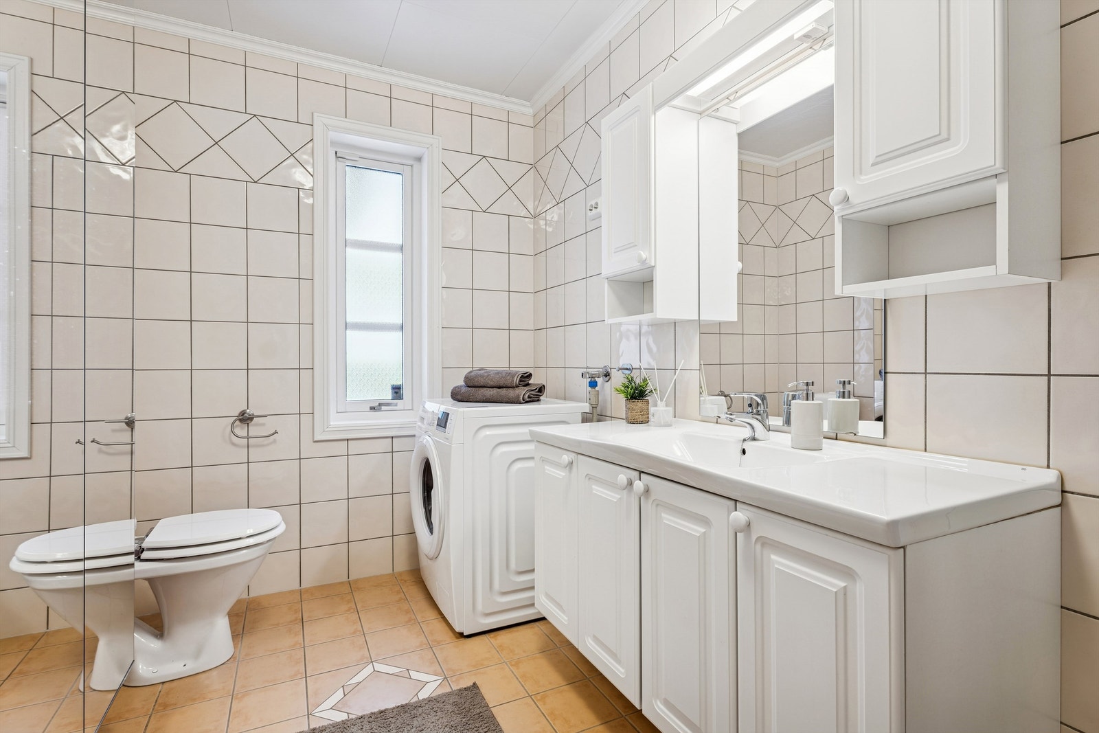 Badet i første etasje er fra byggeår og er flislagt med gulvvarme. Galleribilde