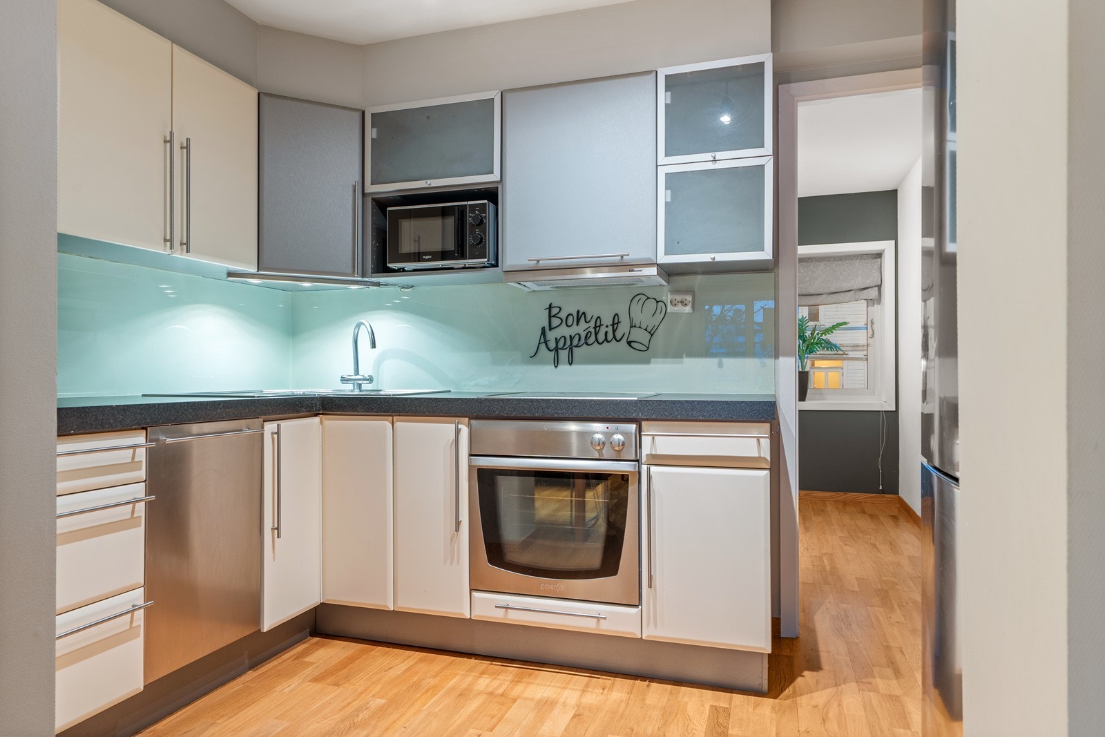 Dobbel aluminiums vask nedfelt i laminat benkeplate, integrert oppvaskmaskin, int. stekeovn med keramisk koketopp, frittstående kjøleskap og micro som også medfølger. Det er spruteplate over hele benkeplata. Galleribilde