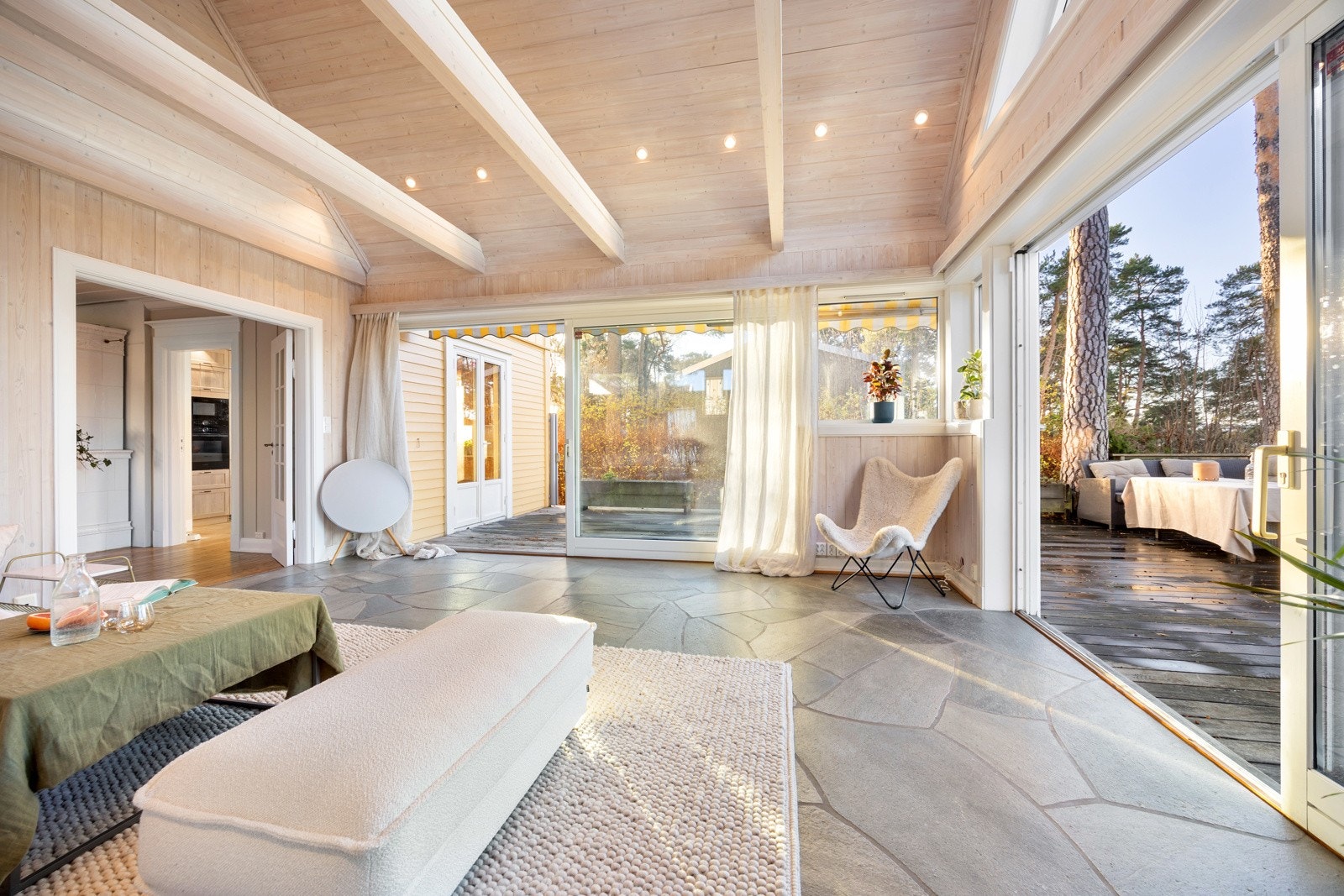 Hovedstuen er boligens naturlige midtpunkt, et særegent og stemningsfullt rom med åpen himling, synlige bjelker og store vindusflater mot sjø og natur.