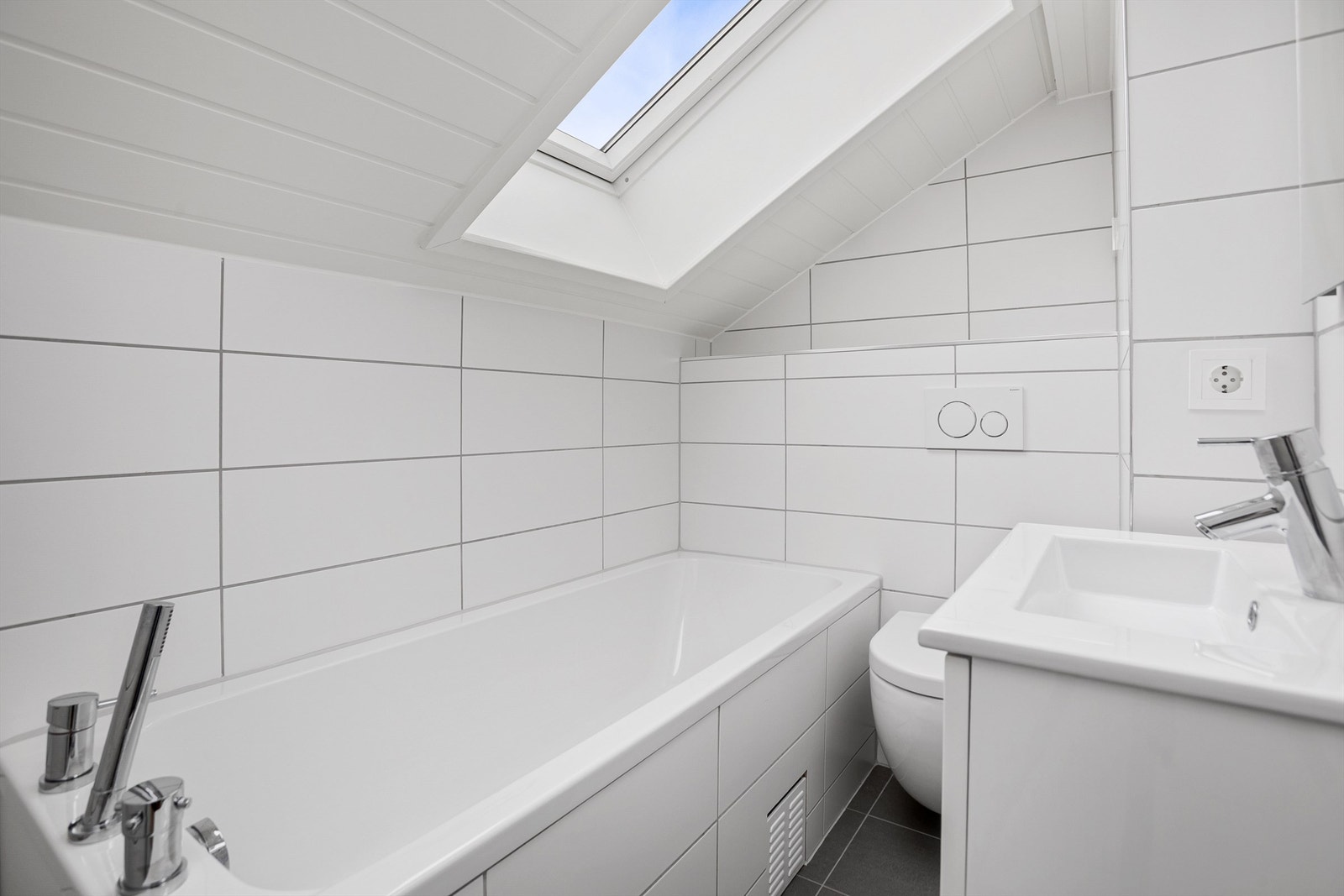 Flislagt bad i 2.etg med vegghengt toalett, badekar samt servantskap Galleribilde