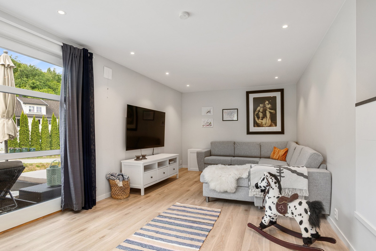 Stuen i utleiedelen er lys og romslig med god plass til sofa og tv-seksjon Galleribilde