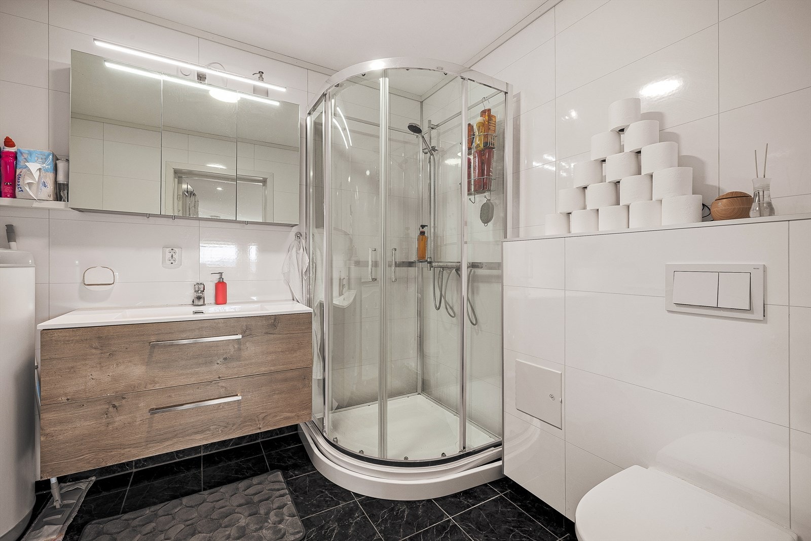 Badet i innredet del/leilighet måles til 5,6m² og består av keramiske fliser på gulv, baderomsplater på vegger og malt platekledning i himling.
Badet inneholder en praktisk servantløsning med møblement/speil, belysning, vegghengt toalett, dusjkabinett. Galleribilde