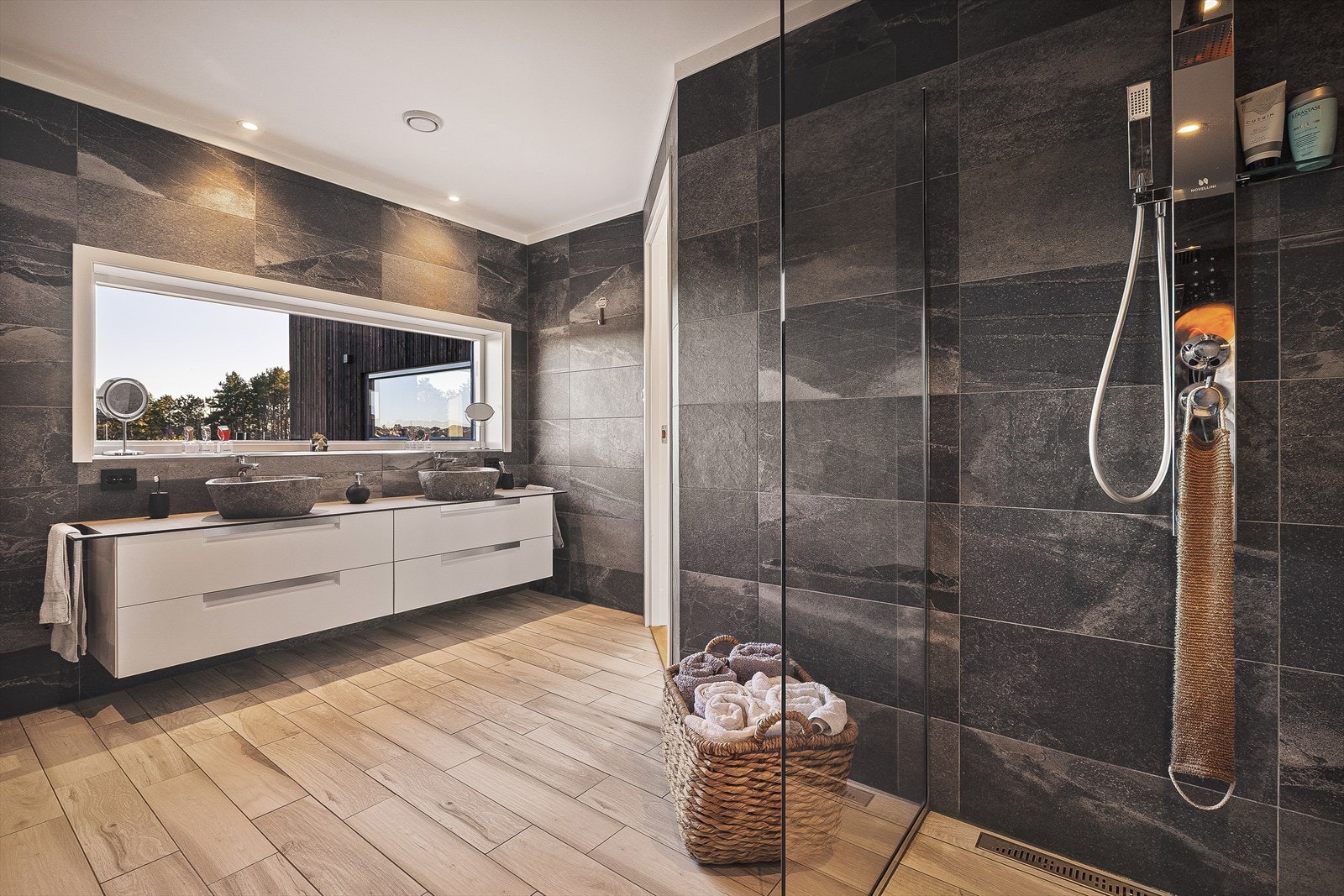 På badet får du baderomsmøbler og gjennomførte detaljer av kvalitet, derav dobbelt dusjgarnityr og dusjvegger, vegghengt toalett og en unik dobbeltservantløsning med utsikt via vindu mot nærområdet. Galleribilde