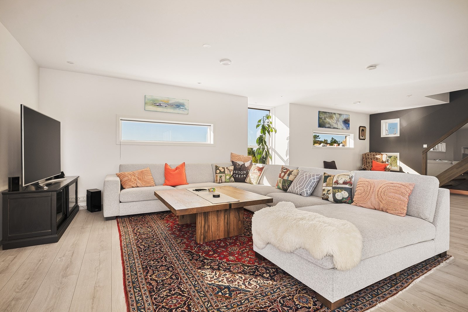 Stuen består av stilrent laminatgulv, malt platekledning på vegger og innfelte spotlights i himling Galleribilde