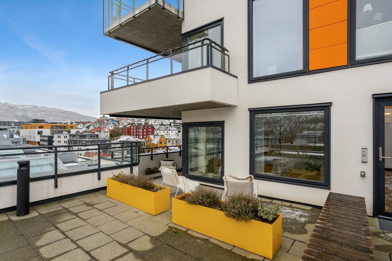 Leiligheten har fine uteplasser, samt enkel adkomst til den felles takterrassen. Området innenfor disse to gule blomsterkassene tilhører leiligheten. Galleribilde