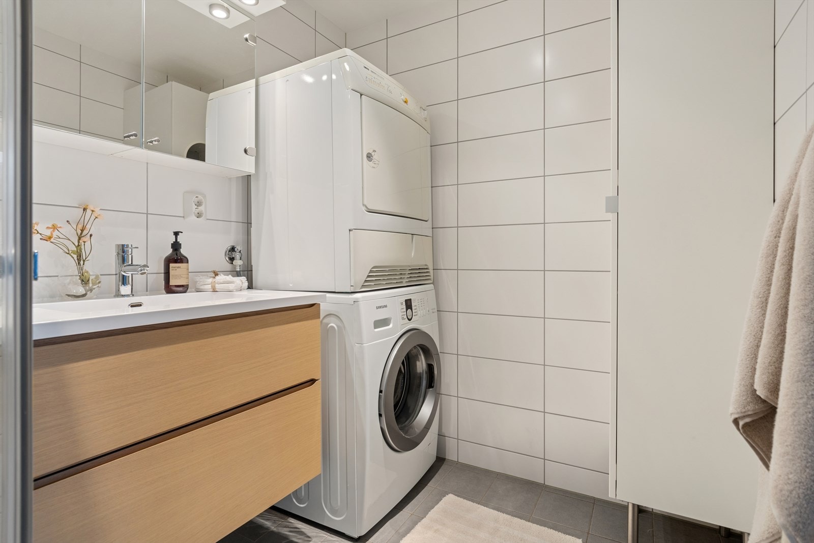 Dette er et kombinert bad og vaskerom fra 2016. Rommet er helfliset med fliser på gulv og vegger, og har et malt tak med downlights. Galleribilde