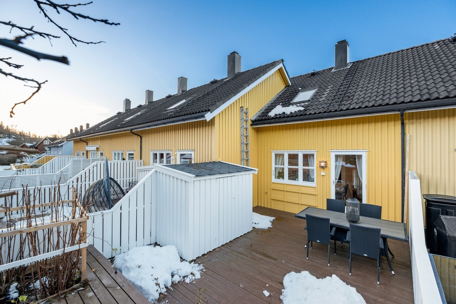 Stor terrasse på baksiden med plass til flere sittegrupper og praktisk utvendig bod Galleribilde