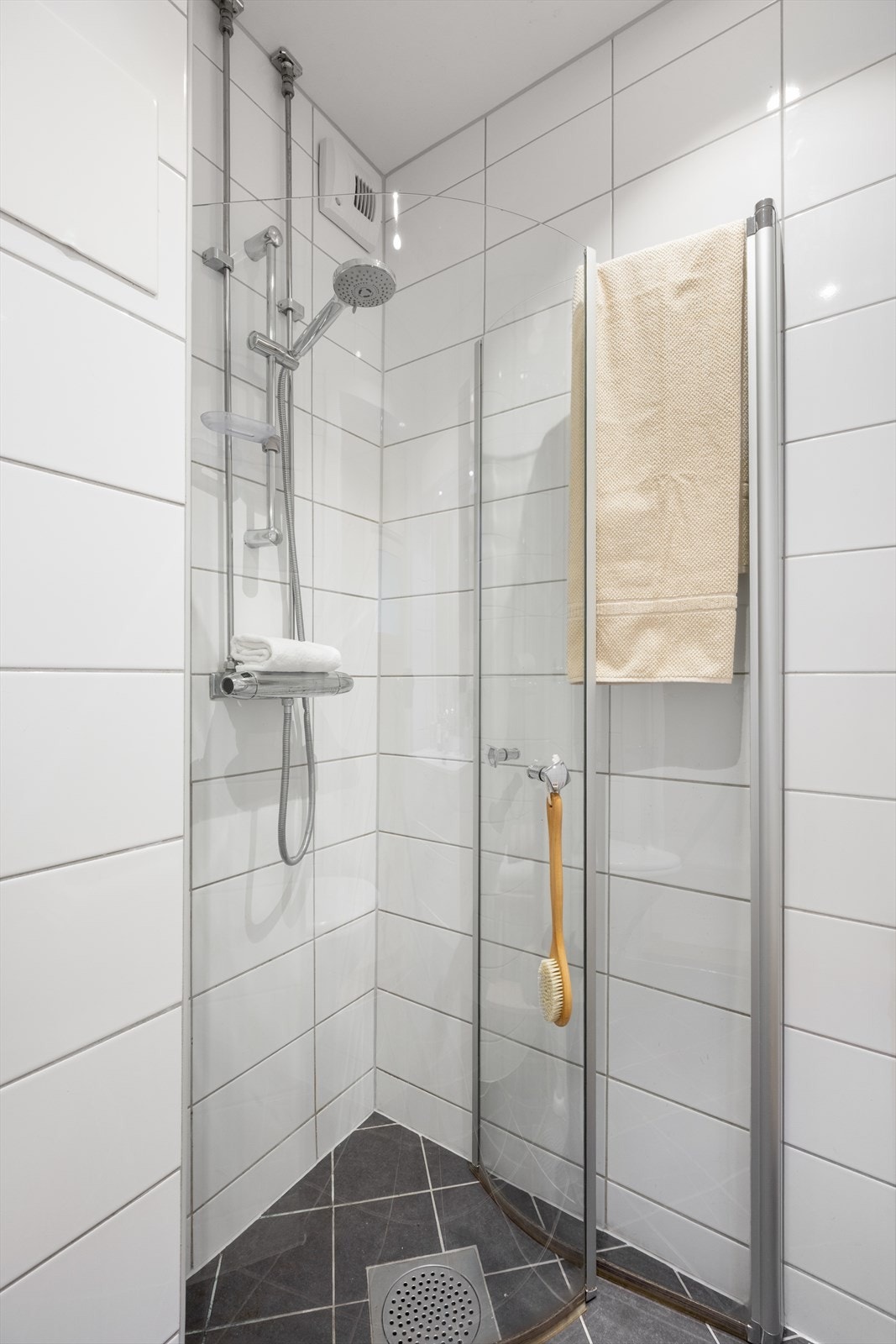 Baderommsinnredningen består av benkeskap (fra 2025) med glatte fronter. Servant (fra 2025), dusj på gulv og veggfestet klosett (fra 2019) med innebygget sisterne. Galleribilde