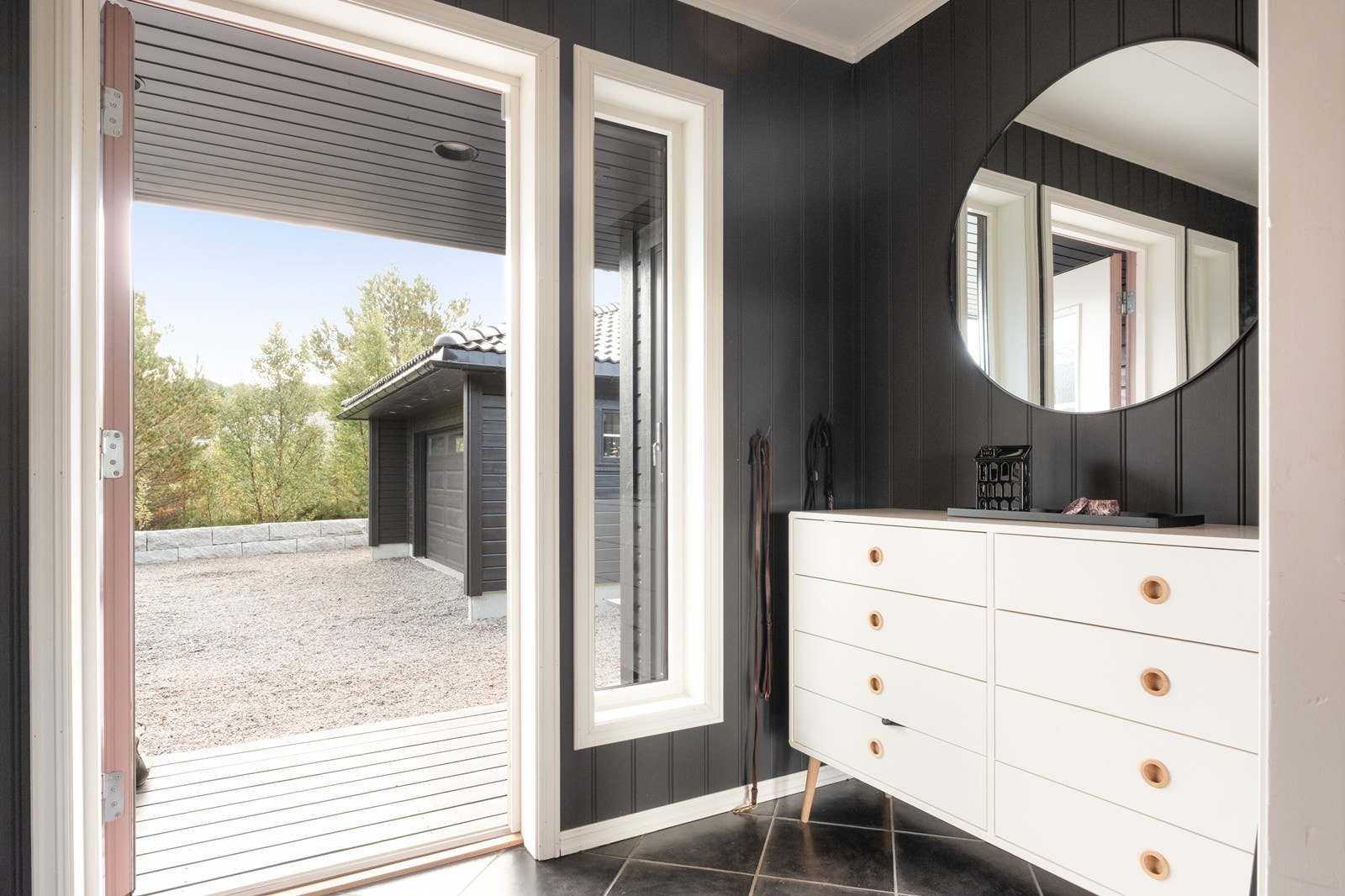 Flislagt gulv gir en praktisk og lettstelt entré med utgang til gårdsplass. Galleribilde