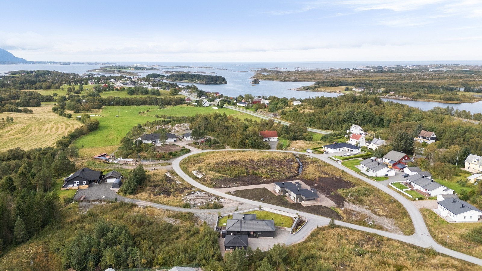 Dronebilde over eiendommen og nærområdet. I det fjerne kan man se Atlanterhavsveien. Galleribilde