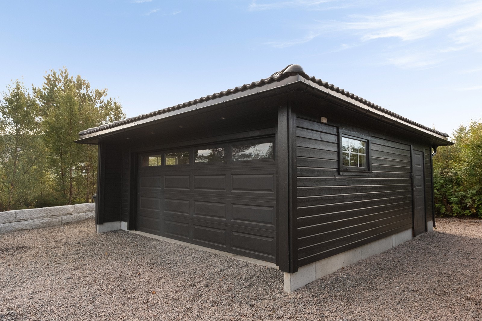 Garasje med isolert stålport og egen inngangsdør gir trygg oppbevaring for kjøretøy. Galleribilde