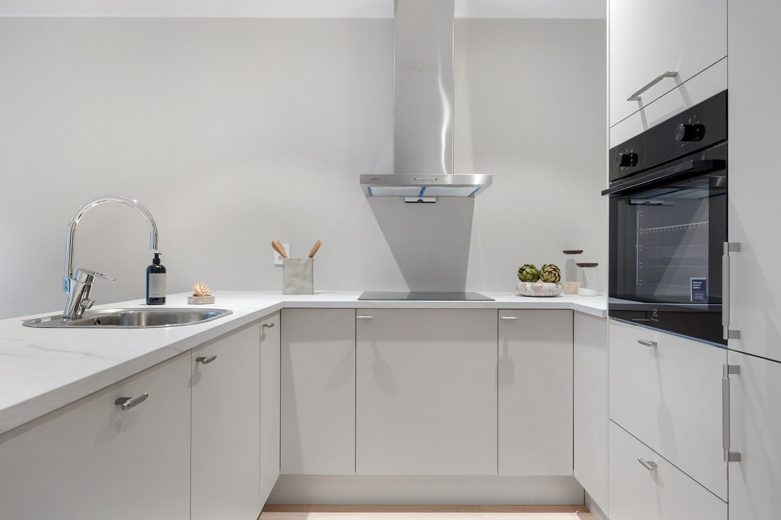 Kjøkkenet fremstår lyst og moderne med stilren innredning og slette fronter Galleribilde