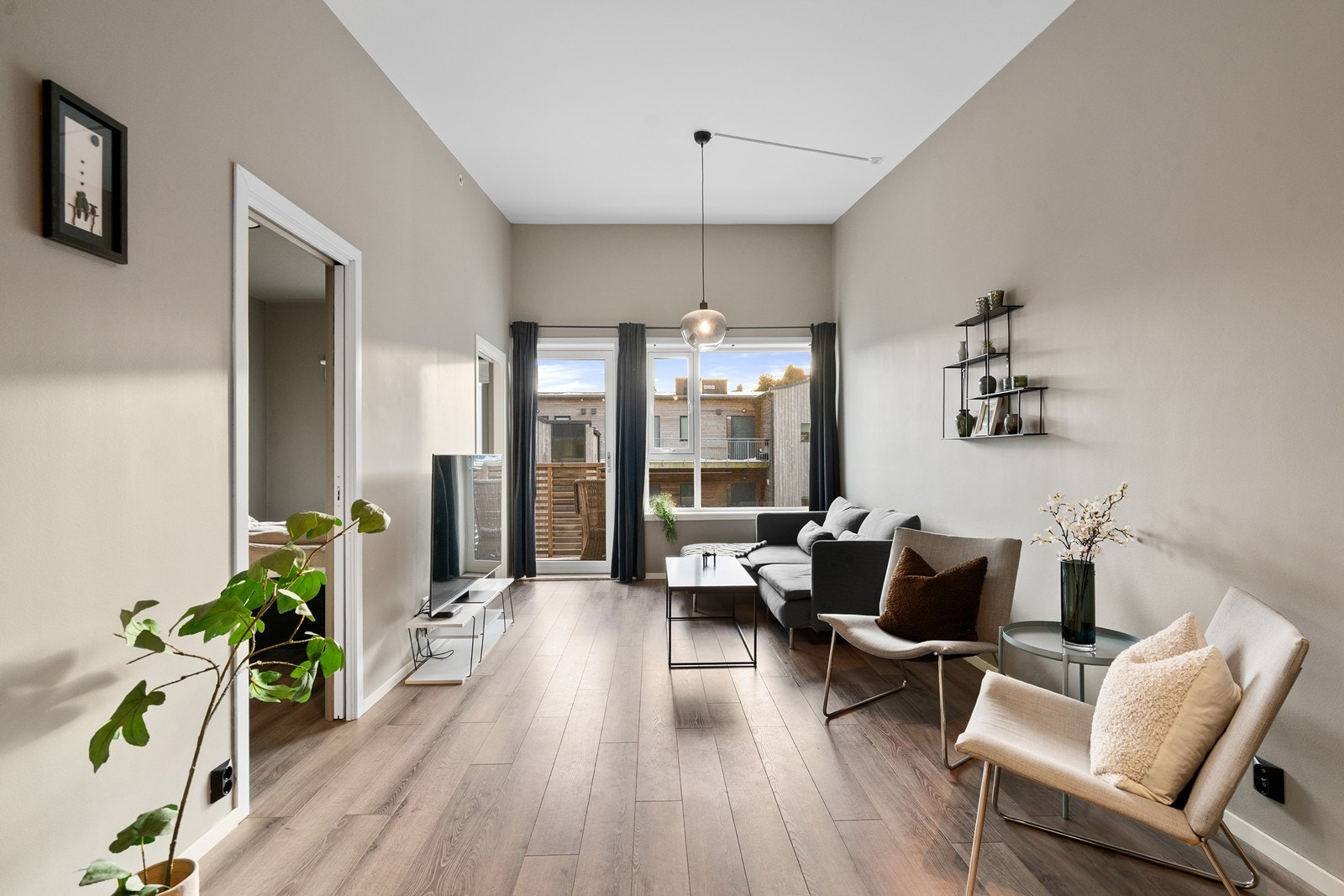 Romslig og åpen stue med lune farger og store vindusflater. Galleribilde