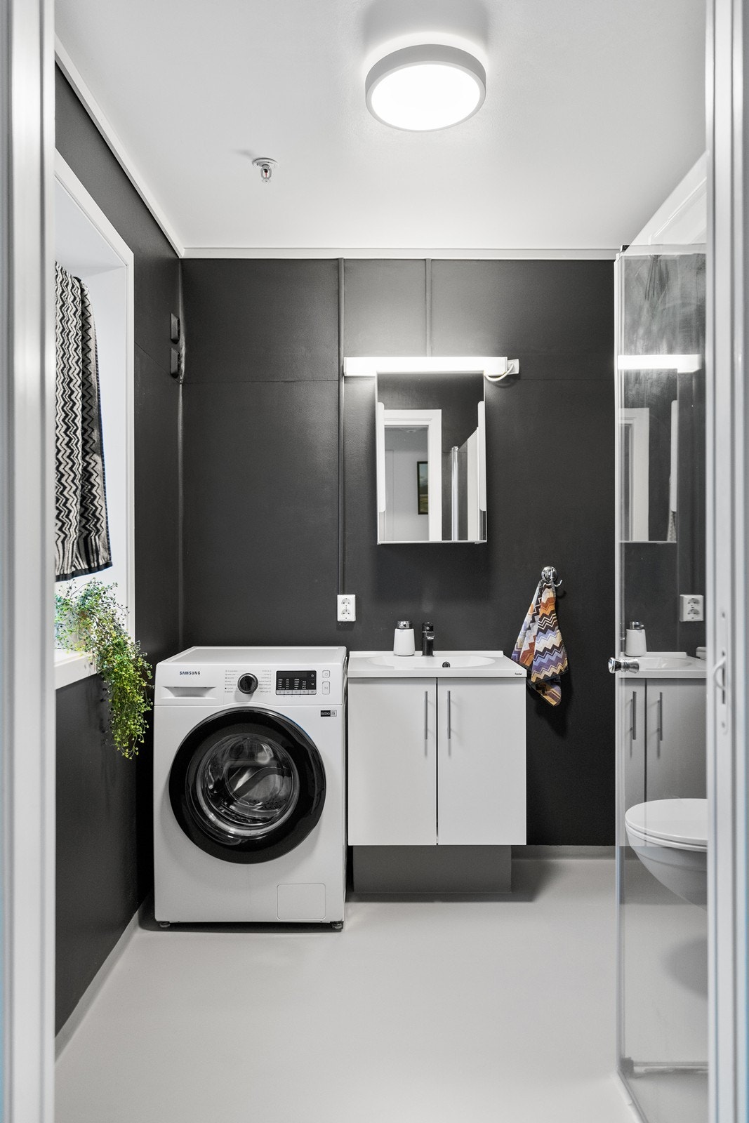 Helstøpt servant med skap og praktisk speilskap over. Plass til vaskemaskin og tørketrommel. Galleribilde