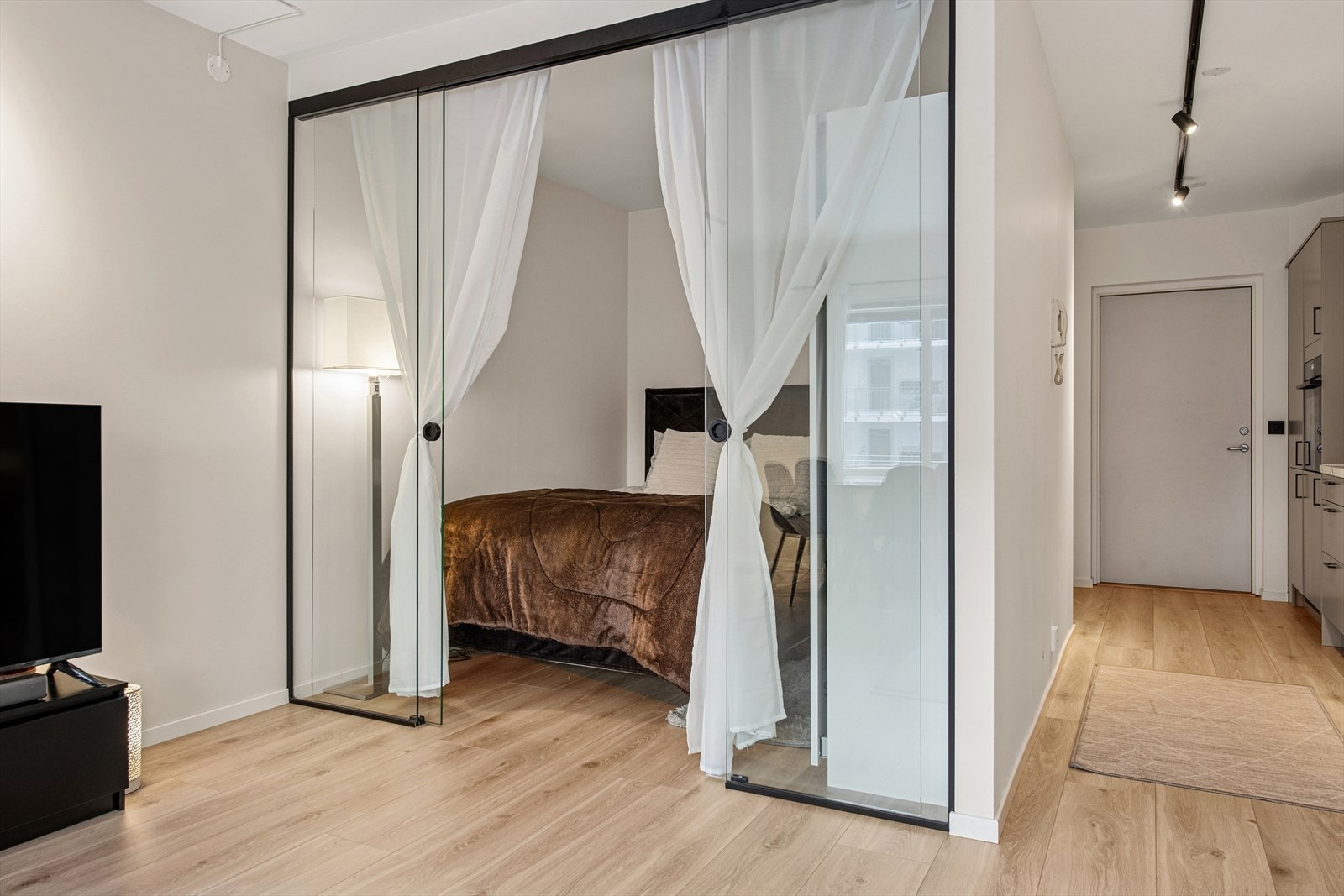 Veldig god plassoptimalisering tillater en sovealkove med en romslig seng og klesskap. Skilledørene i glass er et smykke i seg selv. Galleribilde