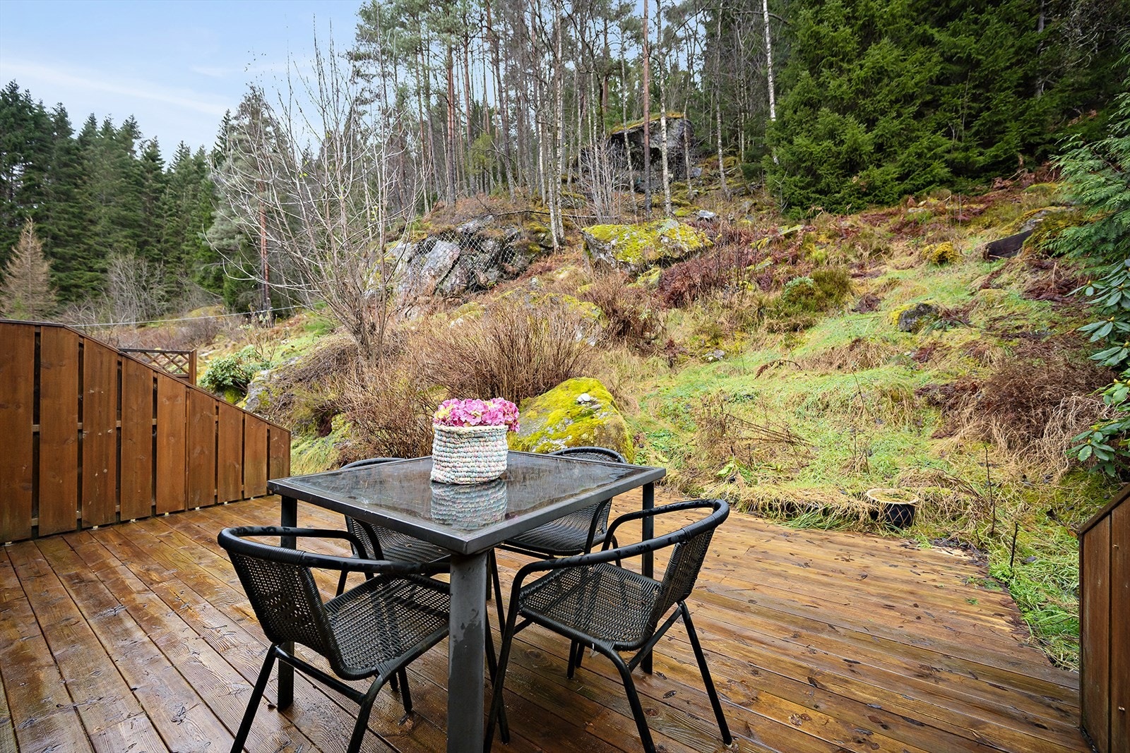 Terrassen har tette levegger og ligger mot et skogsområde, ideelt for utendørs privatliv. Galleribilde