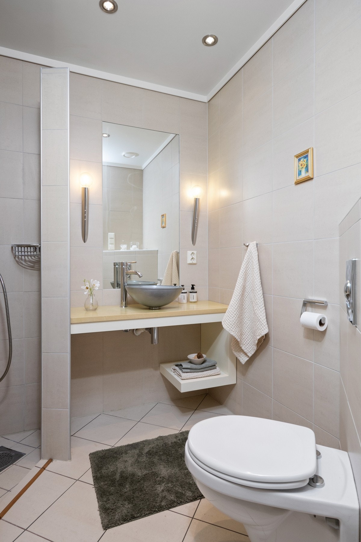 Det andre badet ligger praktisk plassert i tilknytning til entréen, og har lyse fliser på veggene, hvite gulvfliser med gulvvarme og downlights i himlingen. Galleribilde