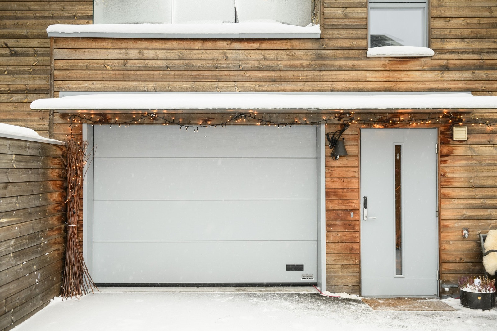 Garasjen har elektrisk port, støpt gulv og ladepunkt for elbil, med ekstra parkering rett foran. Galleribilde