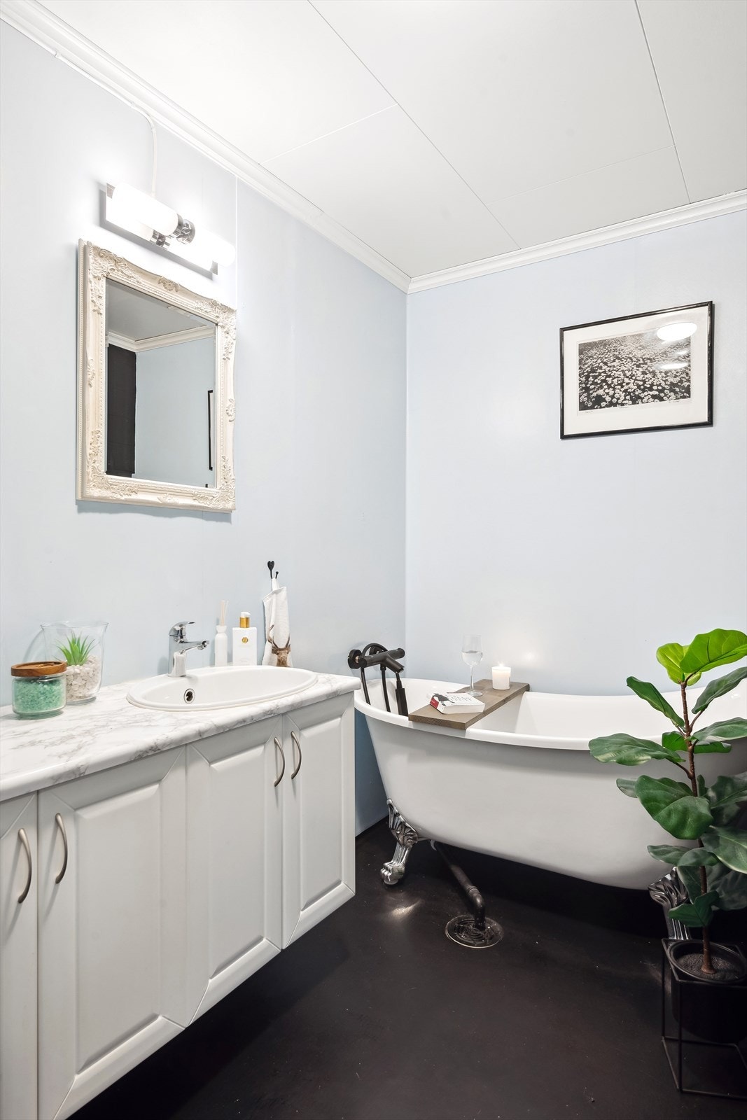 Badet har malte plater/baderomsplater på vegger med vinyl i våtsoner, takess i himling, og malt vinylbelegg med oppbrett på gulvet. Galleribilde