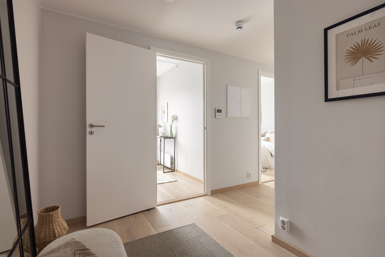Innbydende entré med lyse, glatte vegger, moderne belysning og en-stavs parkett som gir et stilrent og helhetlig preg. Her er det god plass til garderobeløsning. Galleribilde