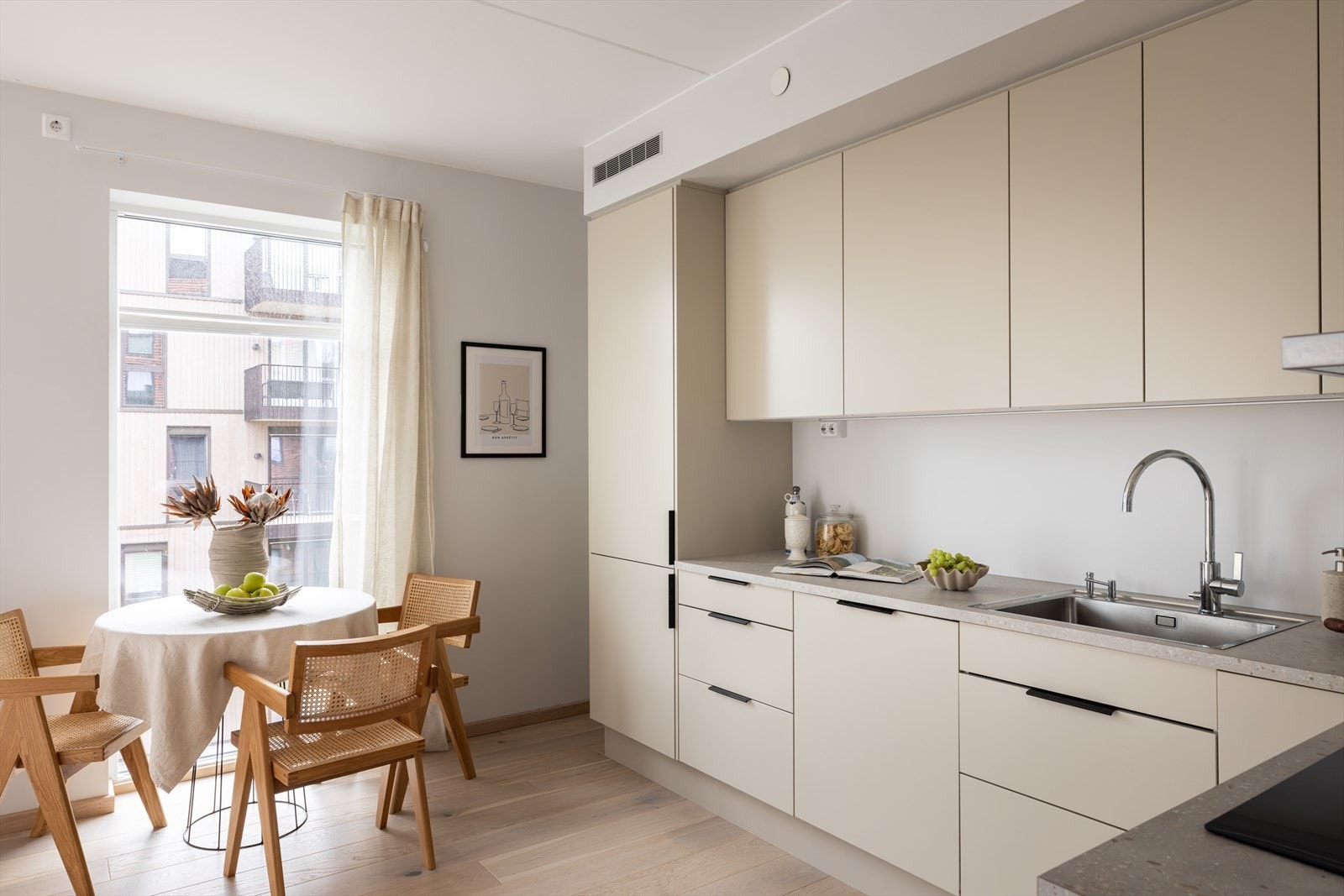 Innredningen fra Sigdal består av lyse, glatte fronter som glir sømløst inn i allrommet, og benkeplaten i beige laminat med nedfelt stålkum gir både funksjon og stil. Galleribilde