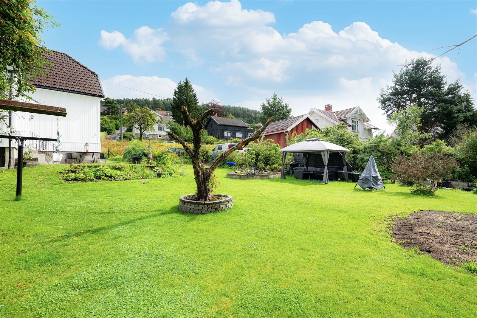 Eiendommen fremstår i dag som en svært barnevennlig og idyllisk tomt med god plass til lek, aktivitet og flere fine oppholdssoner. Galleribilde