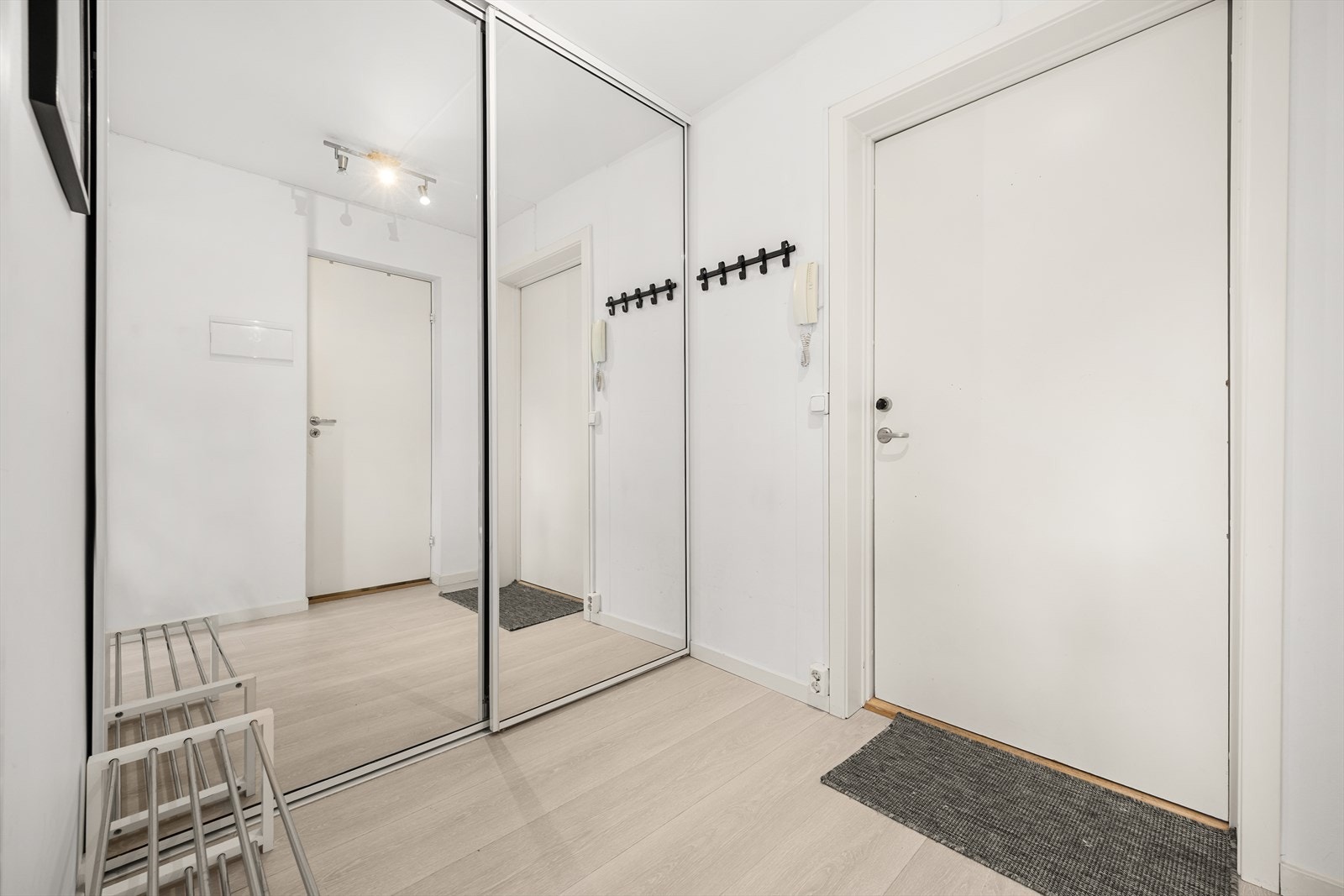 Romslig entré med praktisk skyvedørsgarderobe Galleribilde