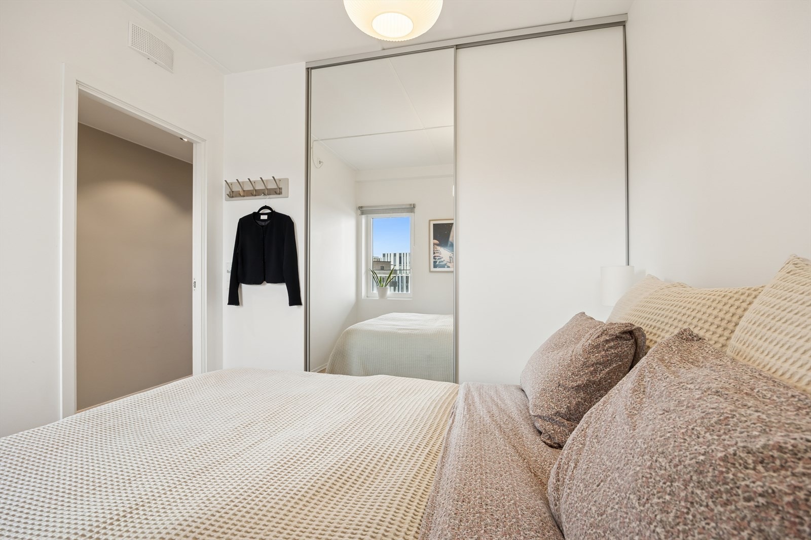 Speilgarderobe med skyvedører gir rommet både stil og ekstra romfølelse. Galleribilde