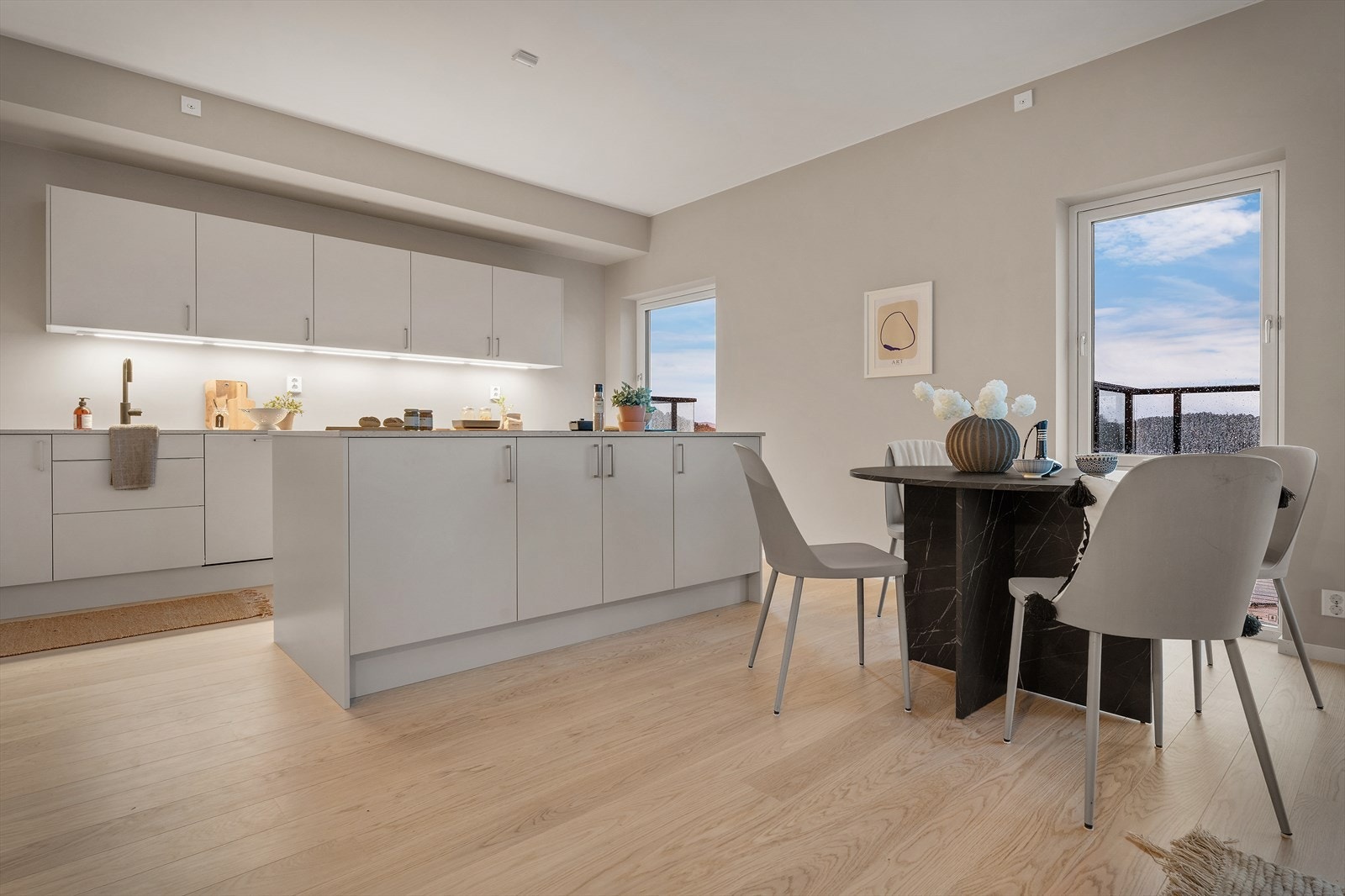 Lyst kjøkken med en funksjonell kjøkkenøy som rommer både oppbevaring og arbeidsplass Galleribilde