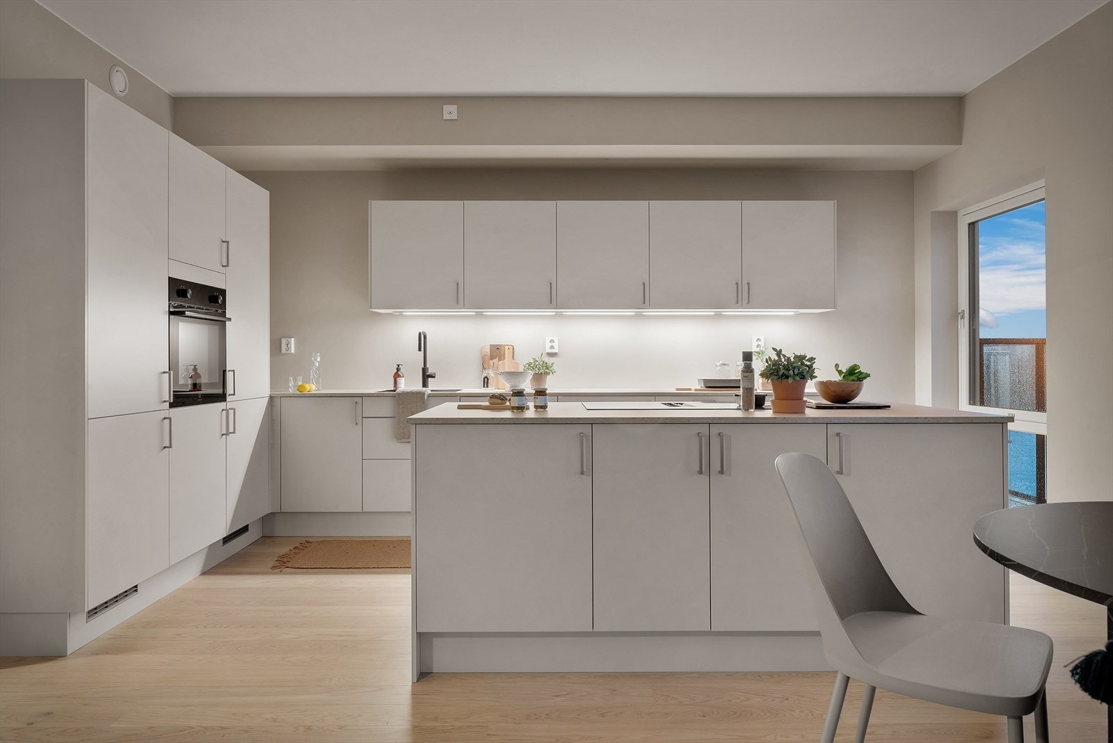 Tidløst og moderne kjøkken med glatte fronter og stor benkeplass Galleribilde