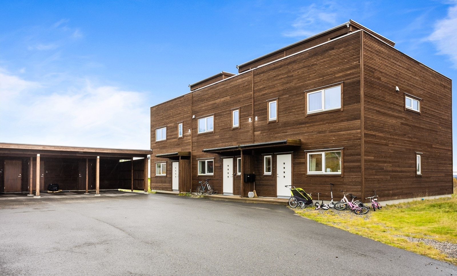 Tomten er pent opparbeidet med plen, asfaltert gårdsplass og carport. Galleribilde