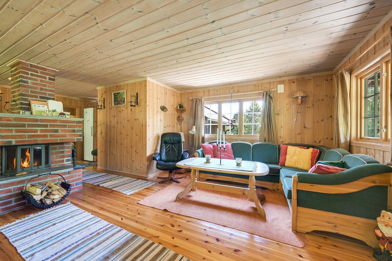 Innbydende stue med plassmurt peis og vedovn. Galleribilde