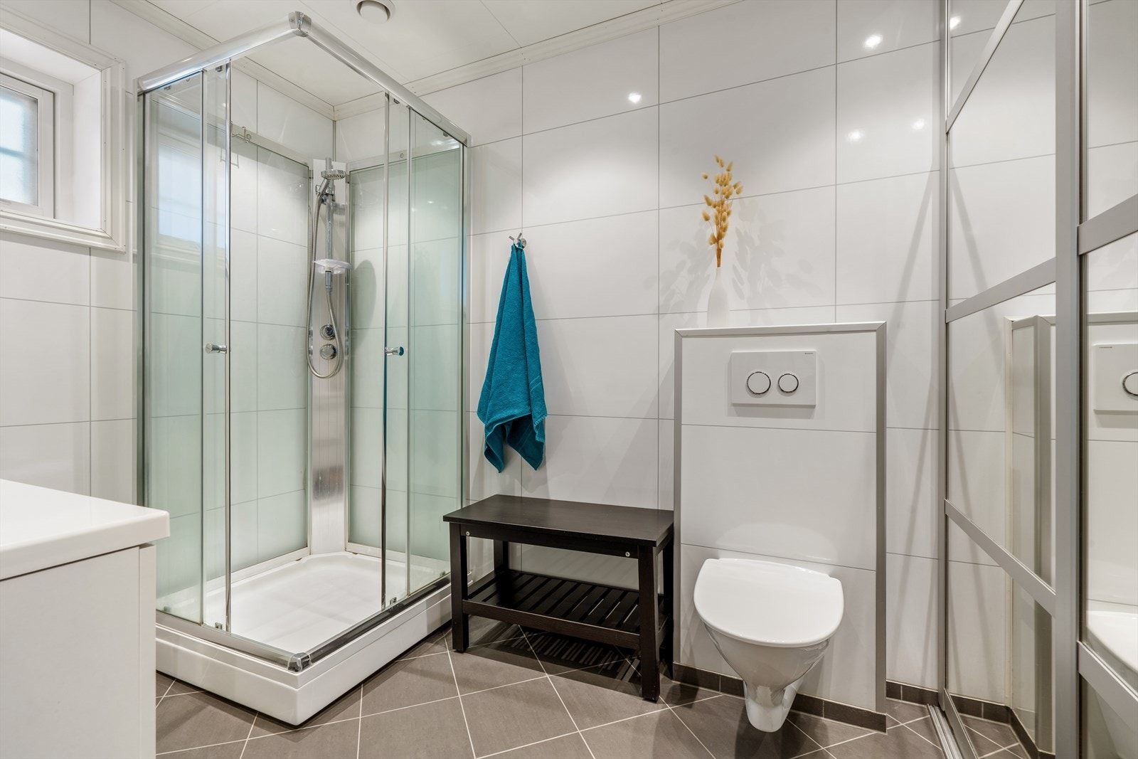 Servant, dusjkabinett, toalett og opplegg for vaskemaskin bak skyvedører Galleribilde