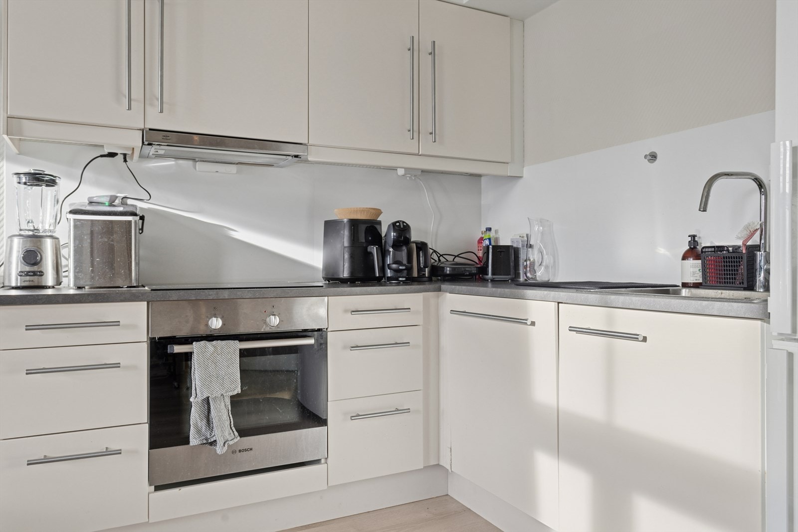 Integrerte hvitevarer og benkeplate i laminat gir et funksjonelt arbeidsområde. Galleribilde