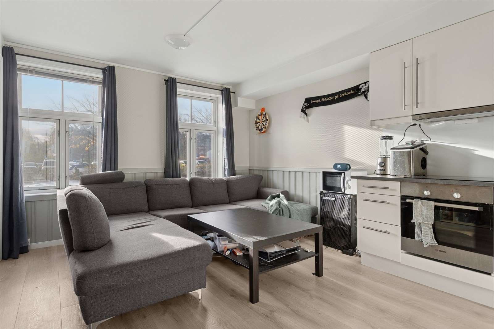 Leiligheten har en romslig og lys stue med åpen kjøkkenløsning. Galleribilde