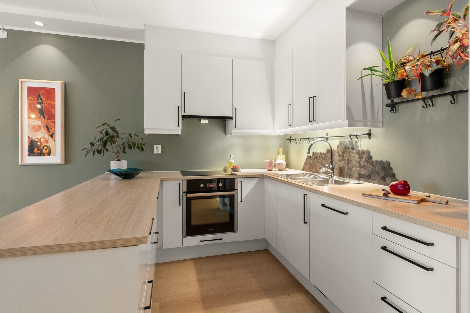 Kjøkkenet har glatte, hvite fronter kombinert med laminat benkeplate i lys treutførelse. Galleribilde