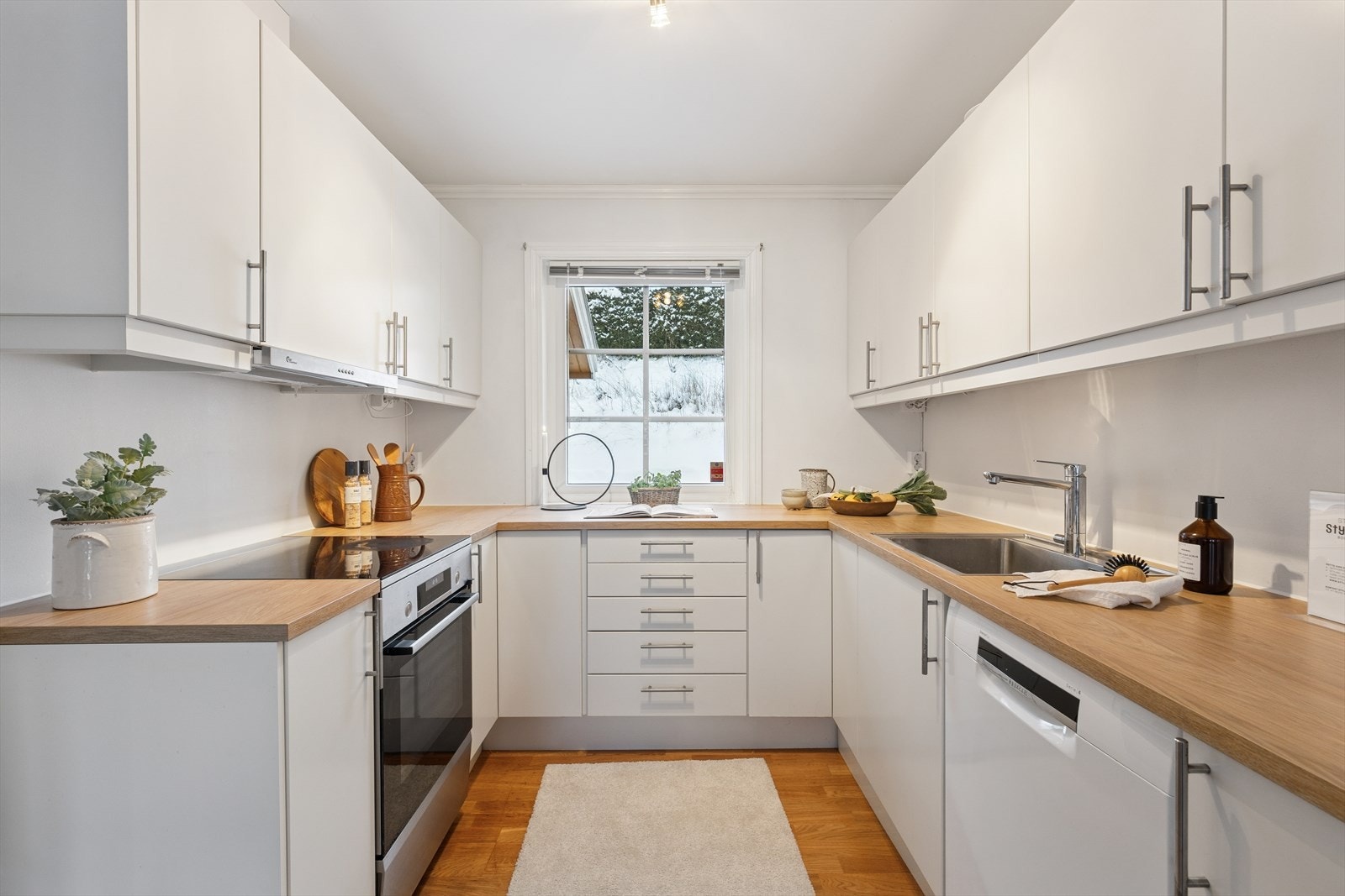 Kjøkken med slette, lyse fronter, laminerte benkeplater og god skapplass. Galleribilde