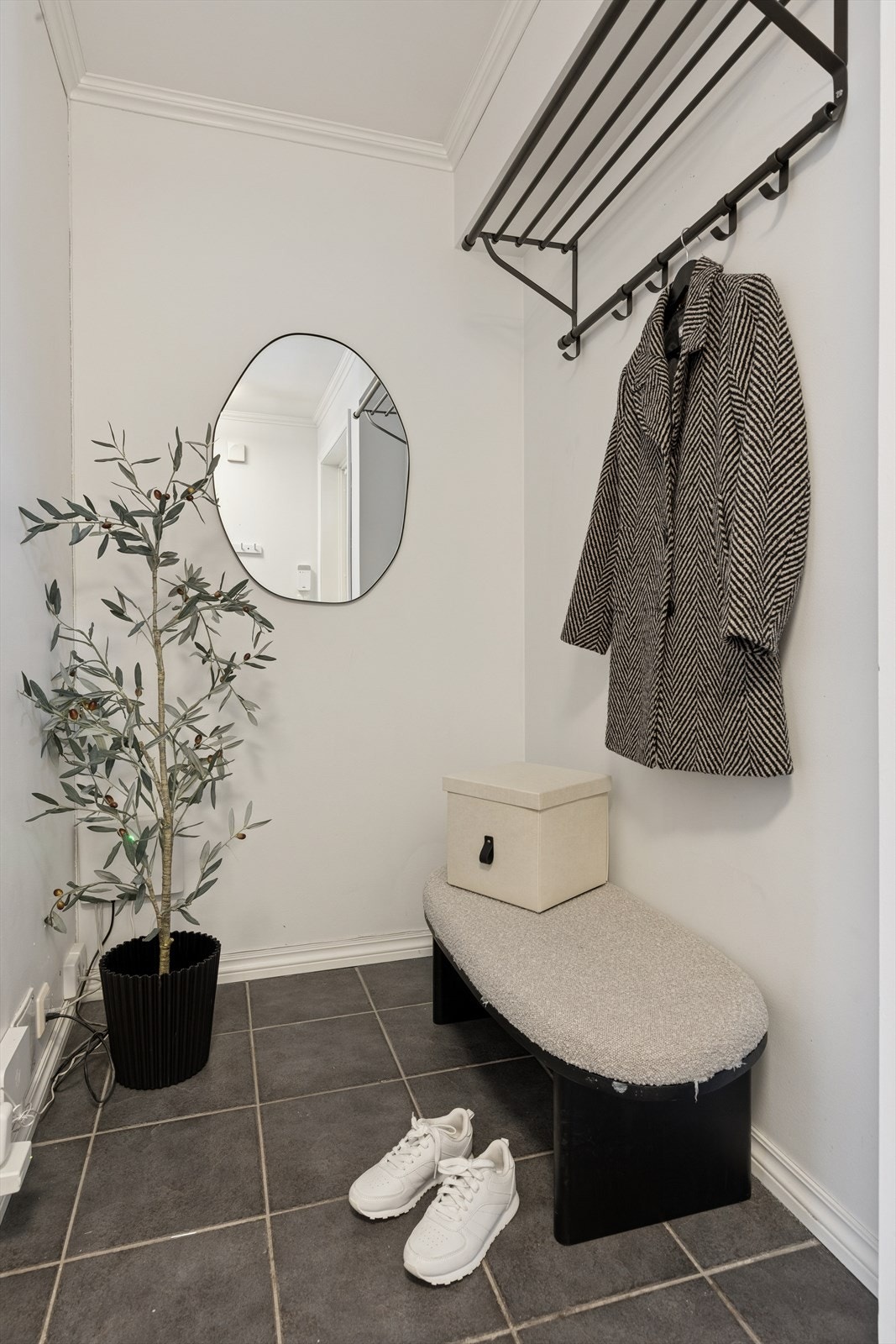 Entréen gir et godt førsteinntrykk med flislagt gulv og lyse, tidsriktige overflater, samt en praktisk garderobeløsning for yttertøy og sko. Galleribilde