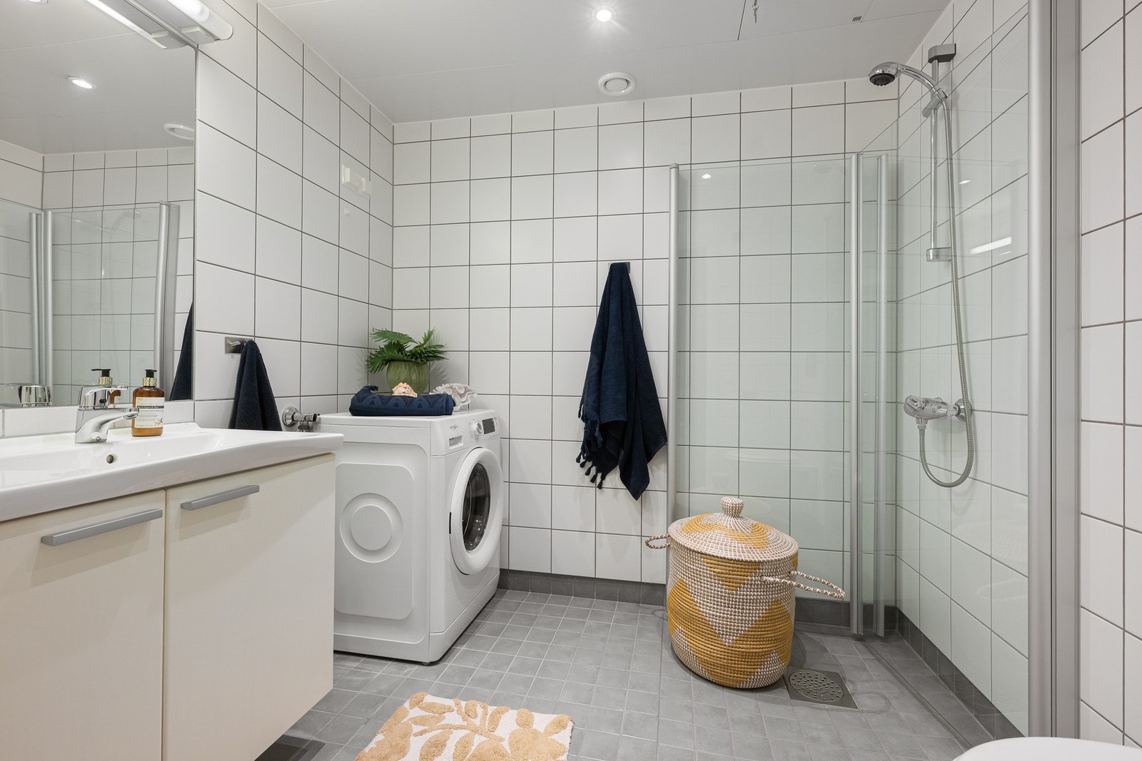 Flislagt baderom med gulvvarme, innredet med vegghengt toalett, dusj med innfellbare glassdører og opplegg for vaskemaskin. Galleribilde