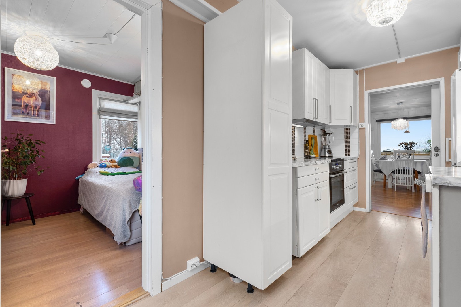 Det er godt utnyttet med benke- og skapplass. Integrerte hvitevarer som platetopp og komfyr samt egen nisjé for dobbelt kjøle-/ fryseskap. Galleribilde