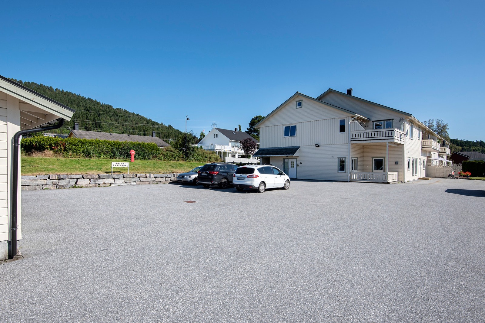 Tomten er for det meste opparbeidet med asfalterte gang og parkeringsareal. Galleribilde