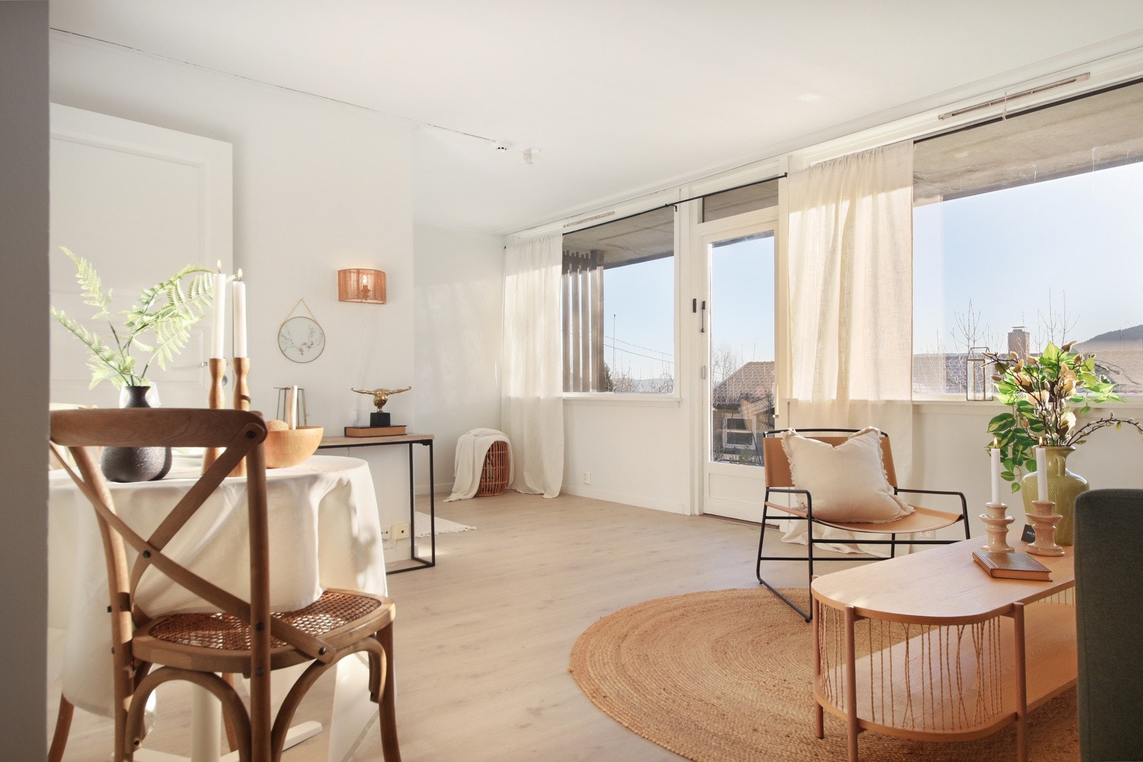 Romslig stue med store vinduer og utgang til uteområde Galleribilde